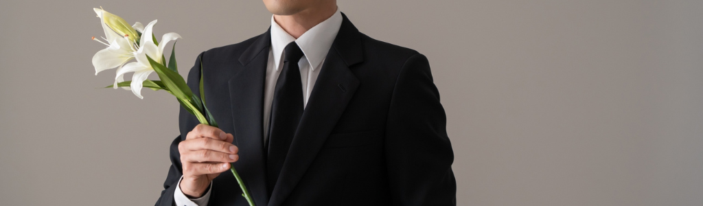 百合の花を持った喪服の男性